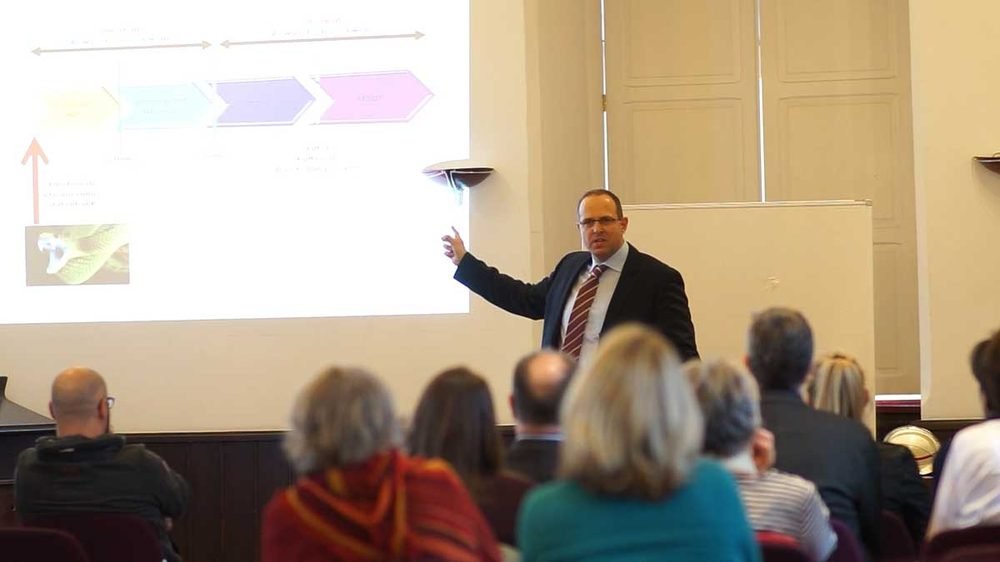 Thorsten Springauf erklärt bei einem Vortrag vor Publikum, was unter Stress im Nervensystem passiert